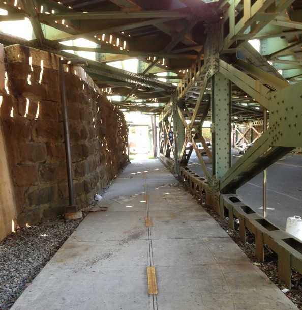 Bike/walk path on sidewalk below train tracks at Jersey Avenue / Newark Street.
