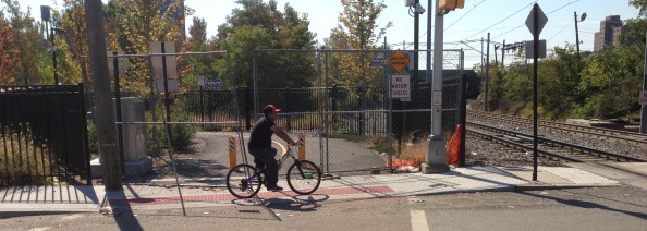 Bike path entrance at New York Avenue / Observer Highway, with construction fences present but easily breached.